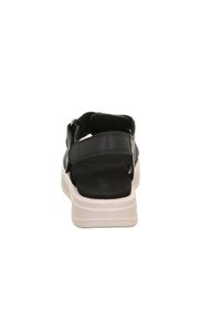 Černá syntetická sandála s dvojitými nastavitelnými pásky, polstrovanou stélkou a bílou gumovou podrážkou, s plochým profilem a otevřeným zadním designem.