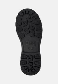 Sole in gomma nera con battistrada profondo, nome del marchio "Camper," modello "Bridge XTRAGRIP," e taglia "38" visibili sul fondo.