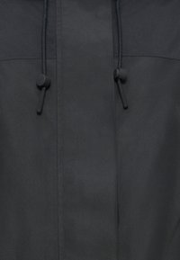 Μαύρο μπουφάν με λεία, ματ υφή. Διαθέτει κορδόνι με μαύρους πλαστικούς κωδικούς στο γιακά και αντίθετη ραφή.