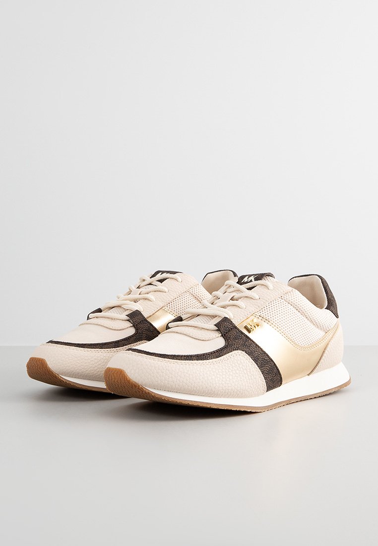 Baskets beiges et marron avec un tissu en maille et texturé, accents dorés, semelle blanche et lacets plats, présentant un bout arrondi et un design sportif.