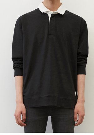 Schwarz langärmliges Poloshirt mit weißem Kragen, aus weichem Material gefertigt. Verfügt über eine Dreiknopf-Leiste und einen geraden Saum. Subtiles Seitenlogo.