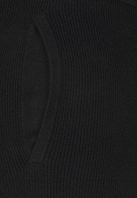 Tissu côtelé noir avec un détail d'encoche en forme de V, mettant en valeur une surface texturée avec un motif régulier sur toute la longueur.