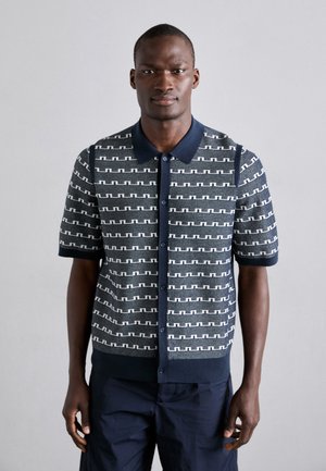 Korte mouwen button-up shirt in marineblauw met wit geometrisch patroon, met een effen marineblauwe kraag en een textuur gebreide stof.
