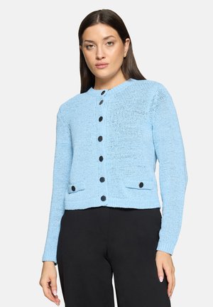 Cardigan bleu clair en maille avec encolure ronde, boutons noirs et deux poches avant, doté d'un design court et de poignets côtelés.