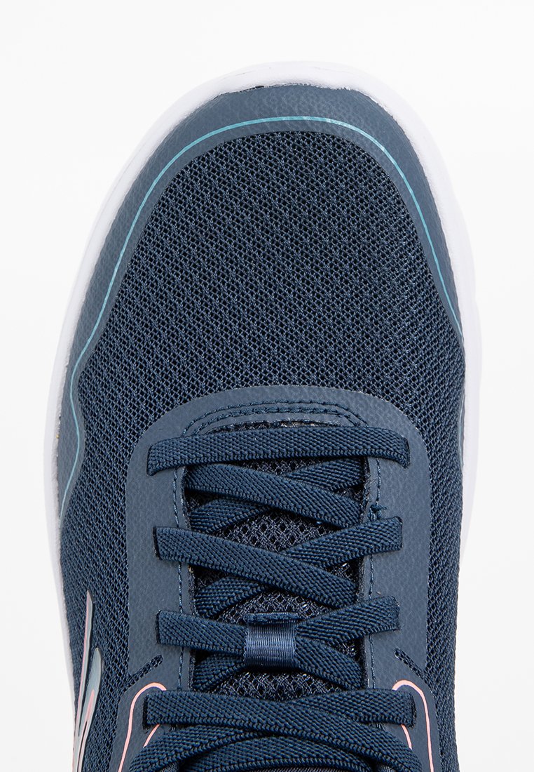 Zapatilla deportiva de malla en color navy con suela de goma suave, punta redondeada y cordones en tonalidad similar. Presenta un acento en azul claro a lo largo del borde superior.