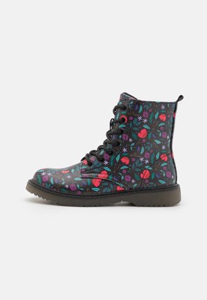 Bottine noire à lacets avec motif floral coloré et semelle épaisse, vue de côté extérieur sur fond blanc.