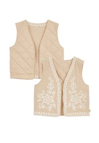 Gilet beige trapuntati con un motivo di ricamo floreale in bianco. I gilet hanno un bordo coordinato e un design senza maniche con apertura frontale.
