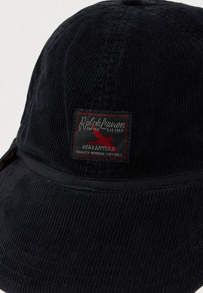 Chapéu de balde em cotelê preto com um patch que diz "Ralph Lauren Garantia de Qualidade Suprimentos ao Ar Livre" e um logótipo de um pássaro vermelho.