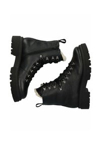 Botas de tobillo de cuero negro con una suela gruesa negra. Cuentan con un cierre de cremallera, ojales metálicos y forro de piel sintética en el borde superior.
