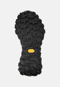 Vibram rubber sole with a rugged tread pattern; predominantly black with a yellow logo. Designed for traction and durability.