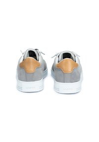 Graue Wildledersneaker mit einem sandfarbenen Lederakzent an der Ferse, weißer Gummisohle und hellgrauen Schnürsenkeln. Minimalistisches Design, schlichter Hintergrund.