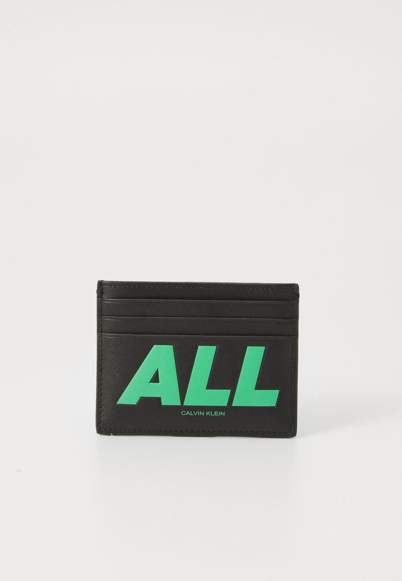 Portafoglio nero in pelle con testo verde "ALL" e "CALVIN KLEIN". Include diversi slot per carte e una superficie texturizzata.