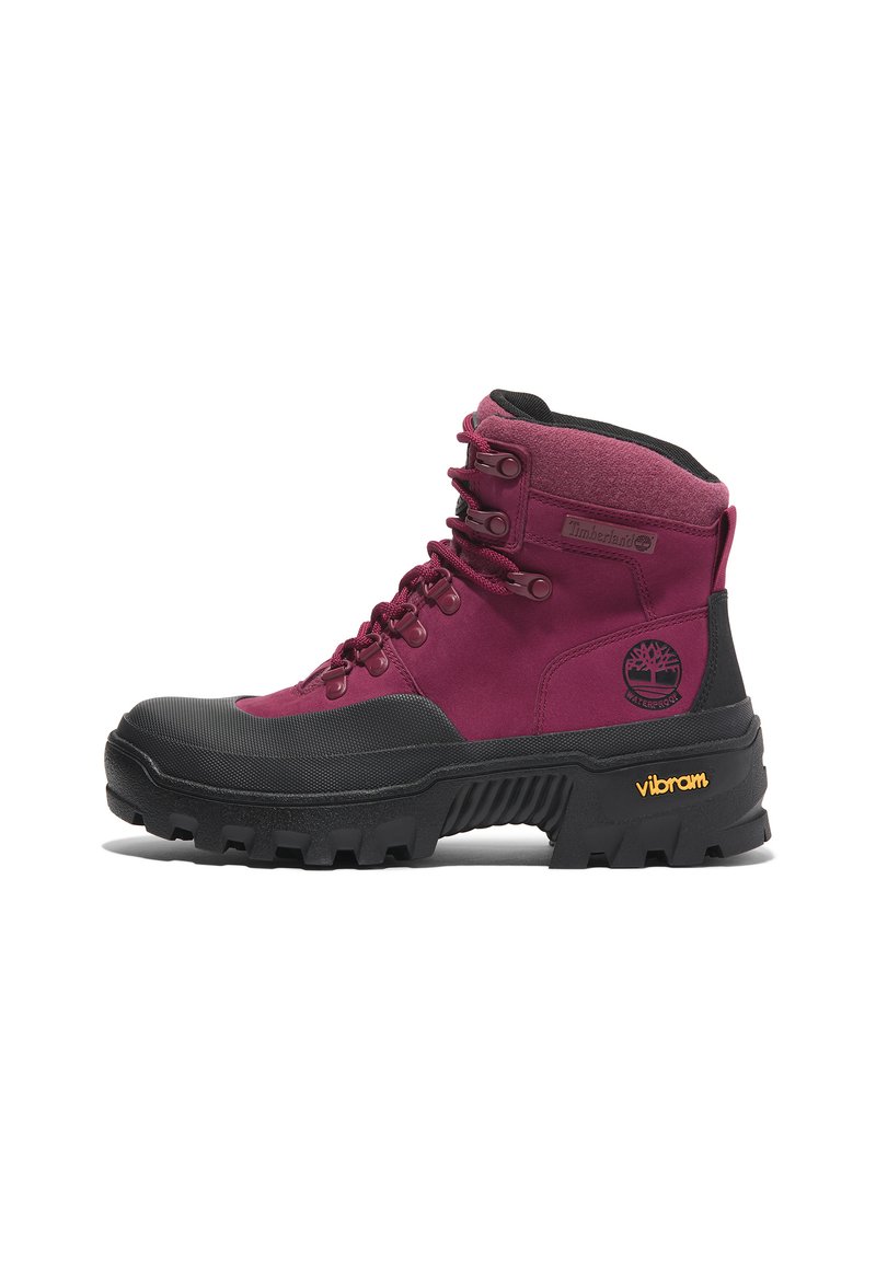 Botte imperméable bordeaux avec des accents en caoutchouc noir, bout renforcé, col rembourré et semelle extérieure Vibram dotée de profondes gommes pour une adhérence optimale.