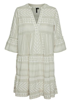 Rochie bej deschis cu modele geometrice albe, având decolteu în V, mâneci evazate trei sferturi și tiv cu volane în straturi. Textură moale a materialului.