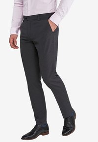 Pantaloni gri, ajustați, cu croială slim, dintr-o țesătură ușoară, cu față plată, buzunare și o textură netedă, asortați cu pantofi negri de birou.