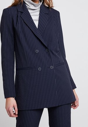 Dunkelblaues, doppelt geknöpftes Blazer mit weißen Streifen, mit Reverskragen, zwei vorderen Taschen und zwei schwarzen Knöpfen, aus glattem Stoff gefertigt.