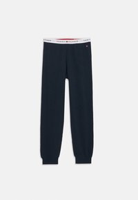 Navy cotton jogger pants with a white elastic waistband featuring "TOMMY HILFIGER" in red and blue. Fitted cuffs at ankles.