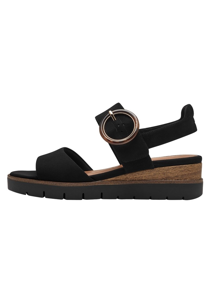Sandalo platform in suede nero con fascia larga e accento metallico rotondo, tacco a cuneo effetto legno e suola in gomma nera texturizzata.