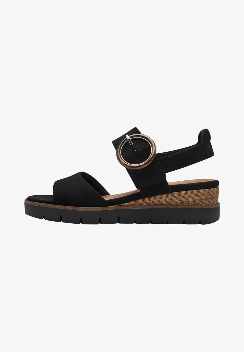 Sandale à plateforme en suède noir avec large bande et accent métallique rond, talon en forme de wedge imitation bois et semelle en caoutchouc noir texturé.