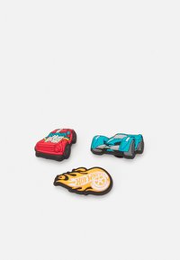 Tri gumeči zatiči: rdeč avto s risanimi detajli, moder dirkalni avto in oblikovanje plamena s tekstom "Hot Wheels" v oranžni in črni barvi.