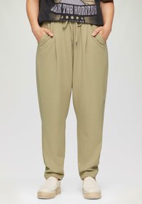 Olijfgroene sweatpants met een relaxte pasvorm, een elastische tailleband en een trekkoord. Heeft zijzakken en een gladde textuur. Casual ontwerp.