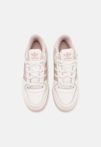 Vita idrottsskor i vitt med rosa och blå detaljer, med en perforerad tåbox, tre ränder och gummisula.