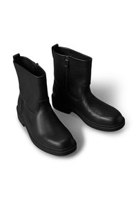 Czarne skórzane botki z teksturowanym wykończeniem, z bocznym zamkiem i solidną podeszwą. Bez ozdób i widocznych elementów metalowych.