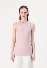 Light pink ribbed tank top with a round neckline, sleeveless design, and fitted silhouette. Smooth texture, minimalistic style, waist-length.