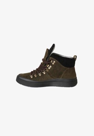 Stivaletti in suede verde scuro con lacci marroni, occhielli metallici e un colletto in corduroy nero strutturato. Suole in gomma con un design robusto.