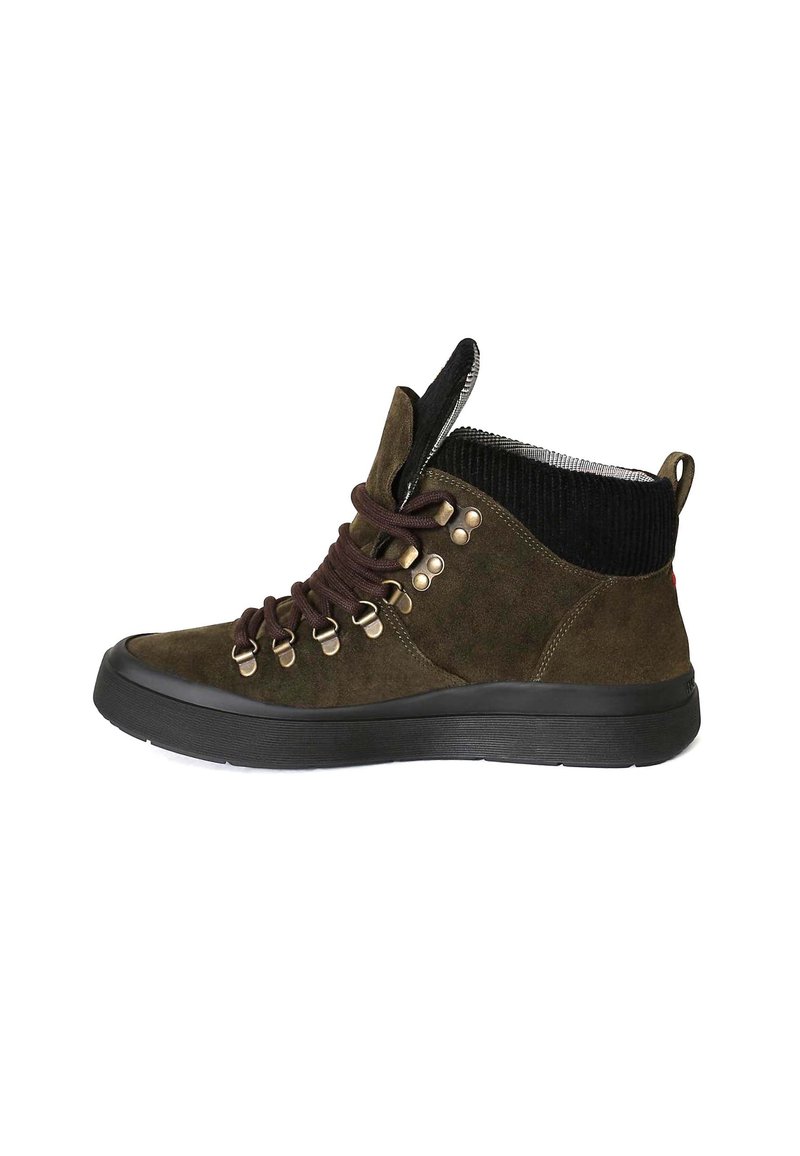 Stivaletti in suede verde scuro con lacci marroni, occhielli metallici e un colletto in corduroy nero strutturato. Suole in gomma con un design robusto.