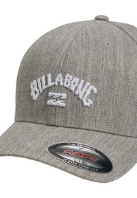 Cappello da baseball grigio realizzato in tessuto testurizzato, con il logo "BILLABONG" ricamato in bianco e una visiera curva. Include un'etichetta di taglia Flexfit.
