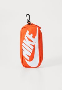 Narancssárga nylon tasak fehér Nike logóval. Cipzáras záródású és fekete klip a rögzítéshez. Téglalap alakú, texturált felülettel.