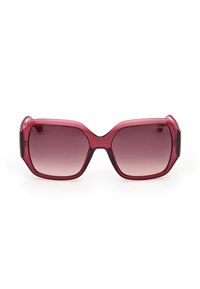Lunettes de soleil carrées surdimensionnées avec des montures translucides rouge foncé et des verres dégradés marron, posées à plat sur un fond blanc.