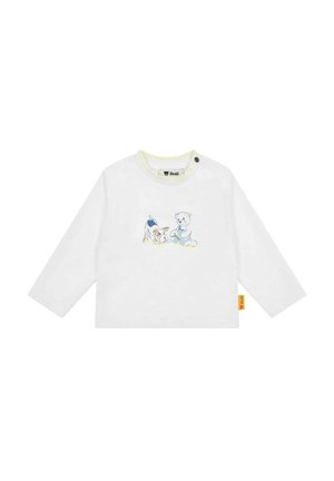 Weißes Langarmhemd mit gelbem Ausschnitt, das eine blaue und beige Grafik eines Hundes und eines Teddybären zeigt. Enthält ein seitliches Etikett.