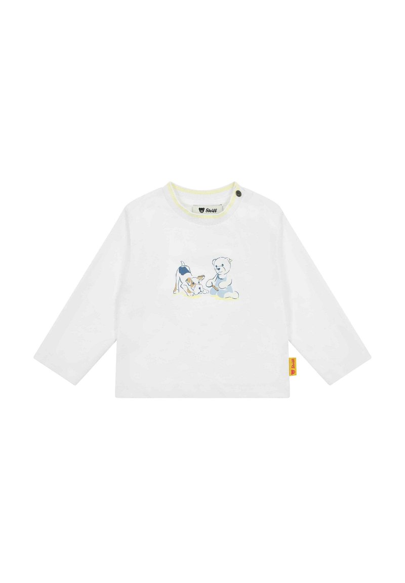 Weißes Langarmhemd mit gelbem Ausschnitt, das eine blaue und beige Grafik eines Hundes und eines Teddybären zeigt. Enthält ein seitliches Etikett.