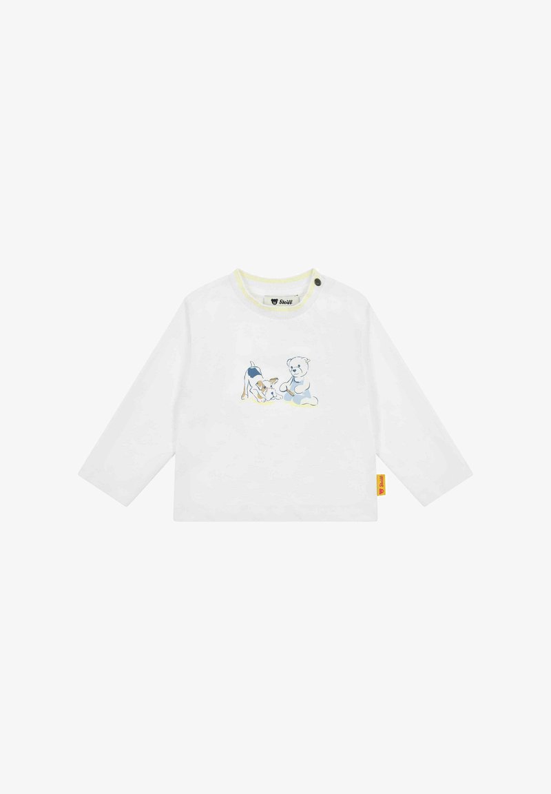 Weißes Langarmhemd mit gelbem Ausschnitt, das eine blaue und beige Grafik eines Hundes und eines Teddybären zeigt. Enthält ein seitliches Etikett.