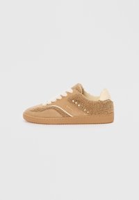 Beige semsket sneaker med fluffy tekstur og kremfargede detaljer. Har flate lisser og små perforeringer for pusteevne. Gummisåle.
