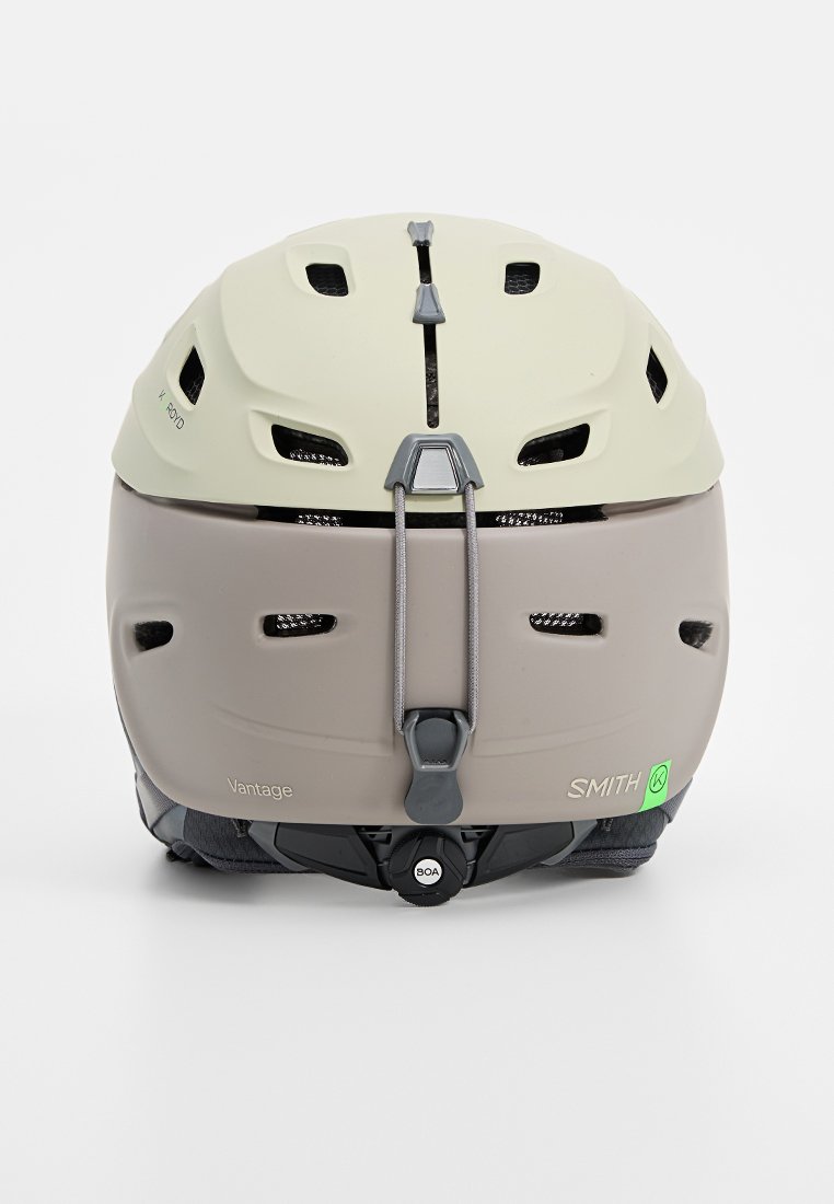 Kask Smith Vantage charakteryzuje się dwutonowym wzornictwem w jasnej zieleni i beżu, trwałą powłoką, licznymi wentylami, regulowanym tylnym pokrętłem oraz bezpiecznym paskiem podbródkowym.