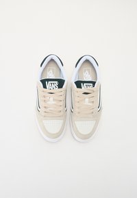 Vans tenisice od bež i bijele kože i suede, s tamnozelenim akcencima, ravnim vezicama i perforacijama na prednjem dijelu.