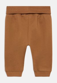 Καφέ παντελόνι για νήπιο με ελαστική ζώνη και ριμπ μανσέτες σε λευκό φόντο.