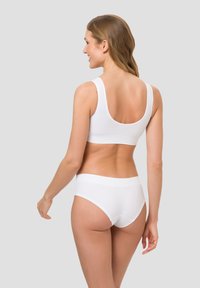 White seamless sports bra and high-waisted panties made from smooth fabric, featuring broad straps and a comfortable waistband.