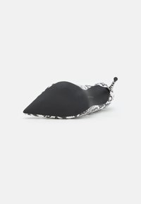 Chaussure à talon haut à bout pointu avec un motif floral noir et blanc, matériau supérieur lisse et semelle noire texturée.