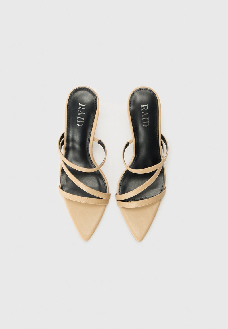 Mules beige à bout pointu avec un design épuré, présentant deux bandes croisées et une doublure intérieure noire. Nom de la marque "RAID" visible sur la semelle intérieure.