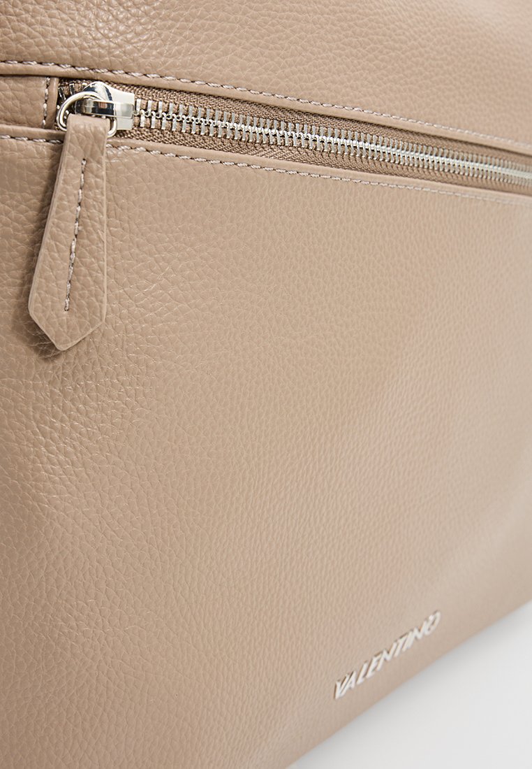 Sac en cuir beige avec une surface texturée, une fermeture éclair en argent et un petit tirant, avec le nom de la marque "Valentino" en relief sur le bas.