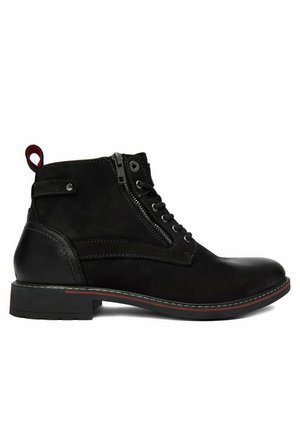 Schwarzer Lederknöchelstiefel mit seitlichem Reißverschluss, Schnürsenkeln, Zuglasche und niedrigem Absatz mit rotem Detail an der Sohlenkante, von der Außenseite betrachtet.