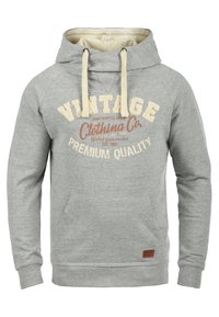 Grijze hoodie met crèmekleurige trekkoorden, een voorkantzak en de opdruk "Vintage Clothing Co" in verschillende kleuren. Zachte textuur van de stof.