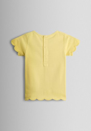 Cămașă galbenă cu mâneci scurte, margini ondulate la mâneci și tiv, și o fâșie cu nasturi pe spate, dotată cu trei capse.