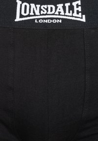 Black boxer briefs with a textured fabric, featuring a white woven Lonsdale London logo on the elastic waistband.