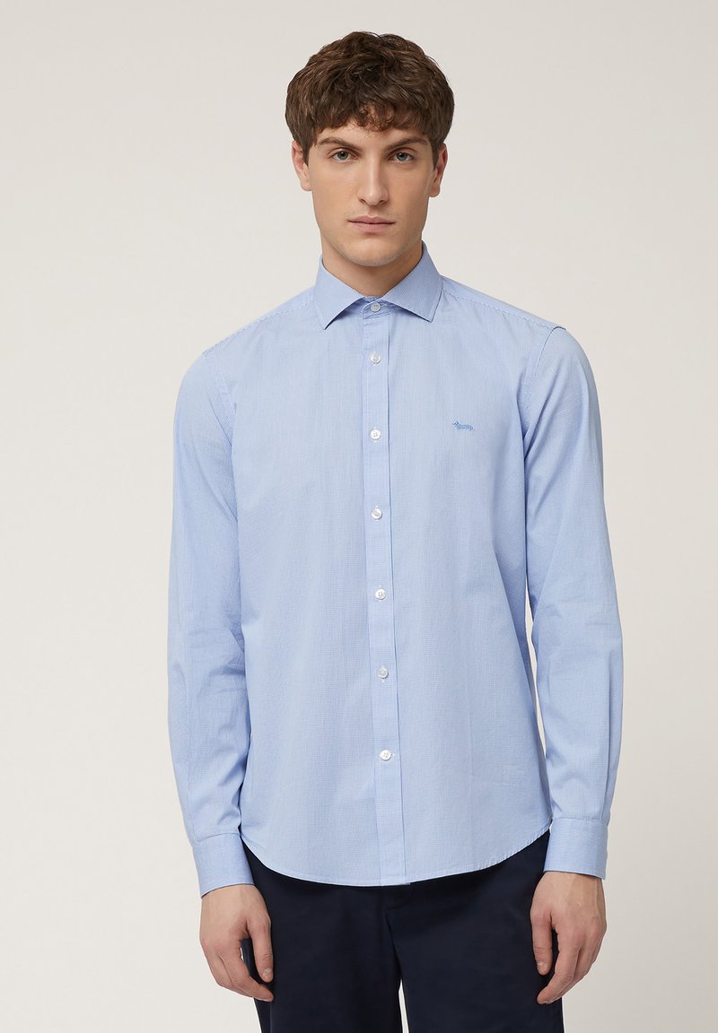 Light blue long-sleeve button-up shirt with a subtle check pattern, white buttons, and a small embroidered logo on the left chest.
