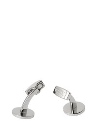 Manžetové knoflíčky ze stříbrného kovu s prohnutým designem, které mají plochý kulatý základ a hladký, leštěný povrch. Na jedné straně jsou vyryté zdobení.